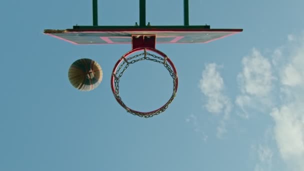 facet sportowiec trenuje z koszykówki na placu zabaw, rzuca piłkę na ring 4k - Materiał filmowy, wideo