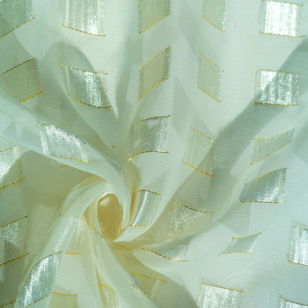 tejido de seda con inserciones de metal cuadradas en platino, ribeteado con una línea esmeralda, aguamarina pastel. fondo texturizado, tarjeta con dibujos - Foto, Imagen