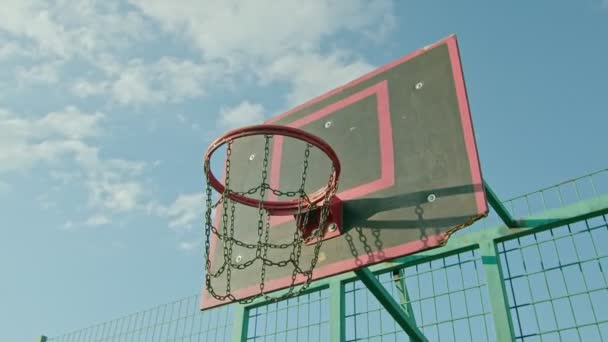 facet sportowiec trenuje z koszykówki na placu zabaw, rzuca piłkę na ring 4k - Materiał filmowy, wideo