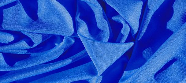 blue silk. Smooth elegant blue luxury silk fabric can be used as an abstract background with copy space, close-up. colorful texture - Photo, Image