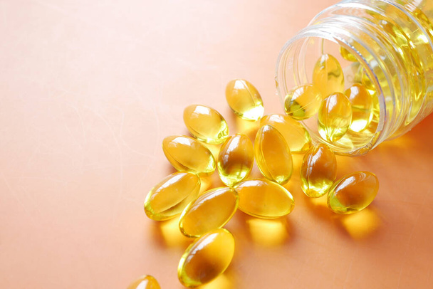 Close-up van veel vitamine capsule op oranje achtergrond  - Foto, afbeelding