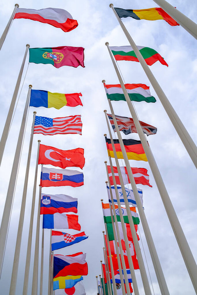 Különböző országok lobogói a zászlórúdokon - Fotó, kép