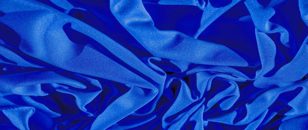 μπλε μετάξι. Λείο κομψό μπλε πολυτελές μεταξωτό ύφασμα μπορεί να χρησιμοποιηθεί ως ένα αφηρημένο φόντο με χώρο αντιγραφής, κοντινό πλάνο. πολύχρωμη υφή - Φωτογραφία, εικόνα