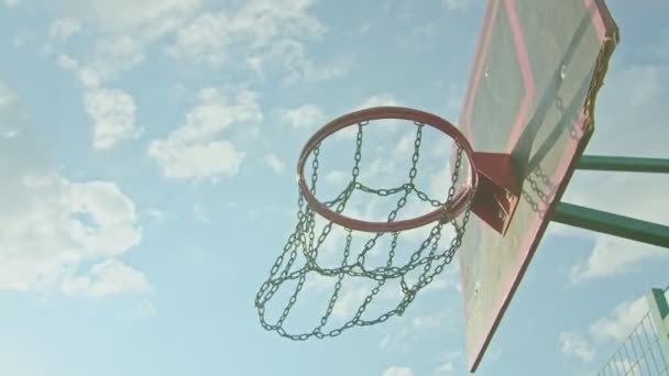 chico atleta entrena con baloncesto en el patio de recreo, lanza la pelota en el ring 4k - Metraje, vídeo