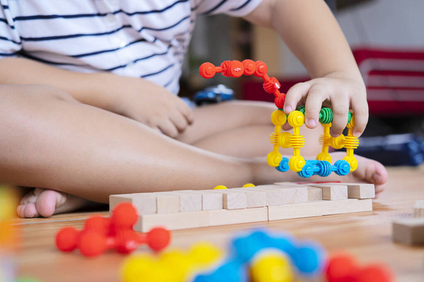 Cute little Asian girl playing with colorful toy blocks. Educational and creative toys and games for young children. Child at home. - Photo, image