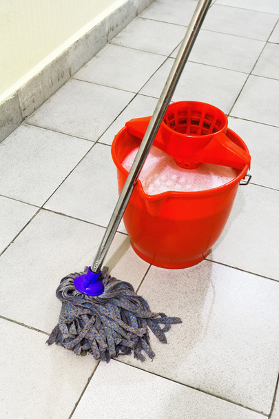 secchio rosso con acqua di lavaggio e strofinare il pavimento
 - Foto, immagini