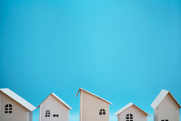 White paper house designs arranged separately on blue background. The empty space can include advertising text. - Photo, Image