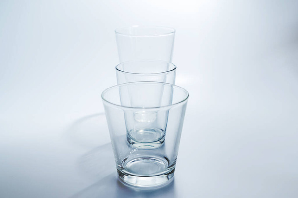 33 empty glasses of various sizes in order of sizes on a white background - Фото, изображение