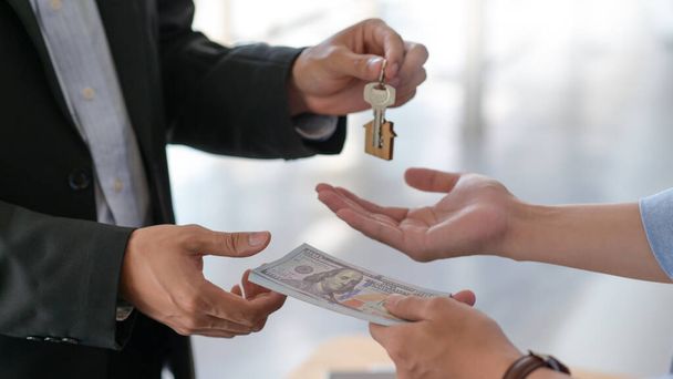 Cropped shot of Exchange of dollars and house keys between buyer and seller. - Fotografie, Obrázek