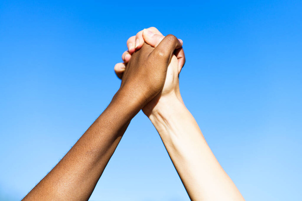 Multiethnic womens hands together against blue sky. - Photo, Image