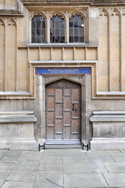 View of english gothic style facade with old wooden door within Old Bodleian Library Courtyard, Oxford, United Kingdom. - 写真・画像