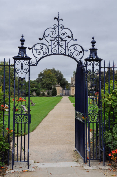 View of decorative garden gate from Trinity College Garden Quad, Oxford, United Kingdom. Overcast Sky. - Photo, Image