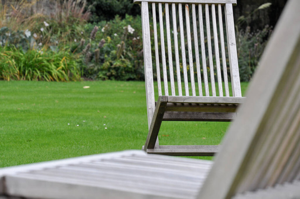 Close-up of folding chairs & english lawn from Trinity College Garden Quad, Oxford, United Kingdom. - Foto, Imagen