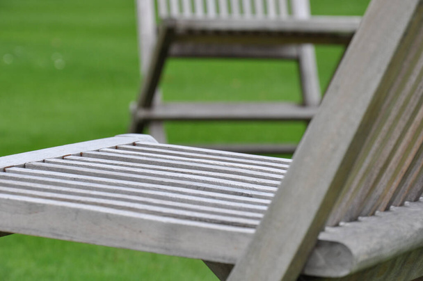 Close-up of folding chairs & english lawn from Trinity College Garden Quad, Oxford, United Kingdom. - Foto, imagen