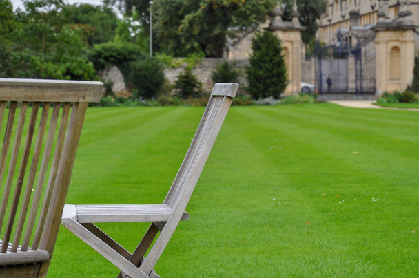 Close-up of folding chairs & english lawn from Trinity College Garden Quad, Oxford, United Kingdom. - Fotó, kép