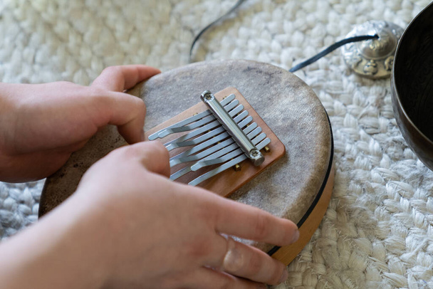 Тибетська практика для звукової терапії: клоап жіноча рука тримає тибетський музичний інструмент для лікування - Фото, зображення