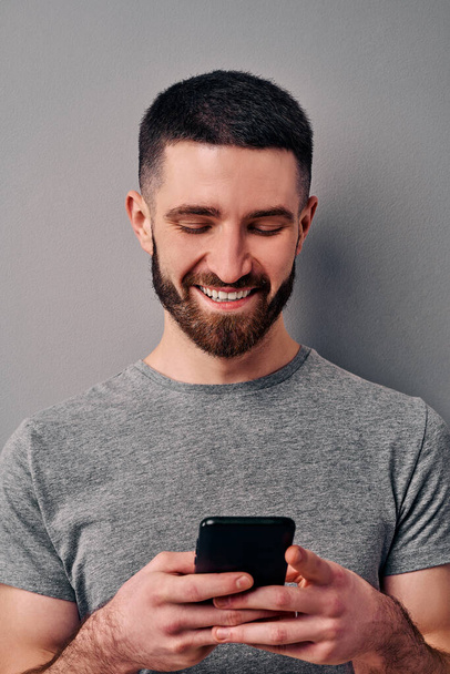 スマートフォンと笑顔を保持するハンサムな男のクローズアップ肖像。オンライン生活技術とソーシャルネットワーキングの概念、ブログ. - 写真・画像