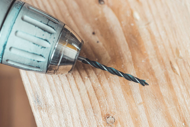 Close up of driller lying on wooden plank - Φωτογραφία, εικόνα