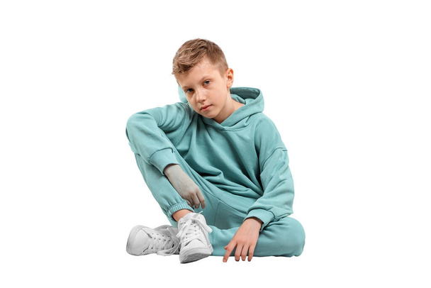 chlapec v tyrkysově modré teplákové soupravy izolované na bílém pozadí - Fotografie, Obrázek