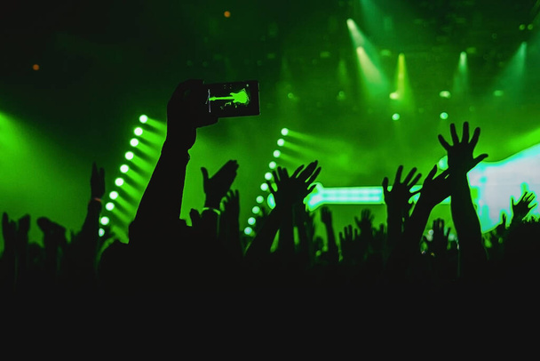 Holding smartphone and photographing concert. - Photo, Image