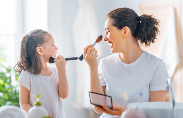 Happy loving family. Mother and daughter are doing make up and having fun. - Fotó, kép