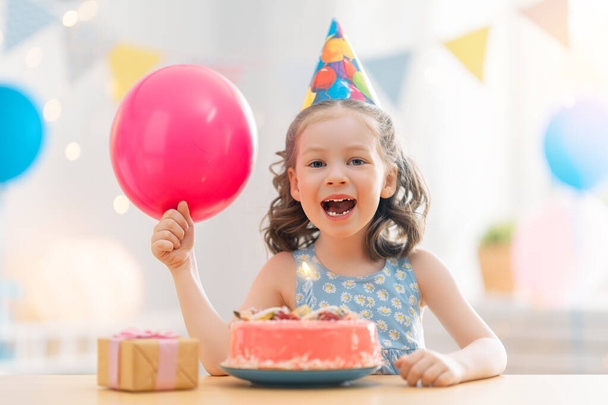 The kid is blowing out the candles on the cake. Child is celebrating birthday. - Foto, Imagem