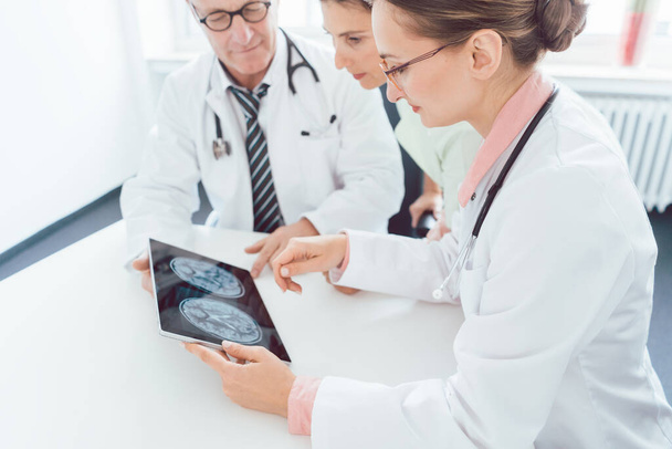 Doktorlar bir tablet bilgisayarda röntgen çekmeyi tartışıyor. - Fotoğraf, Görsel