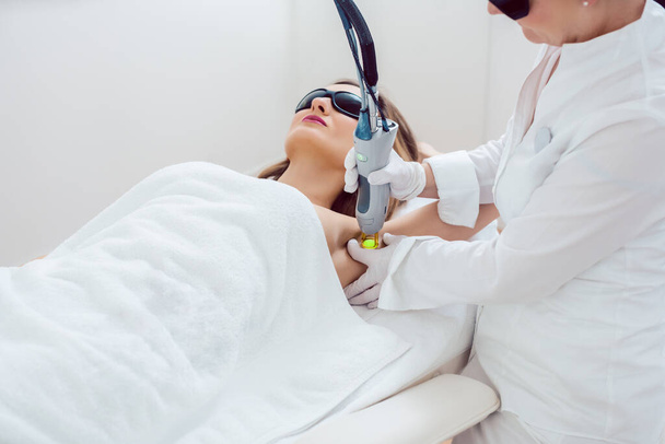 Woman during hair removal using modern laser technology - Photo, Image