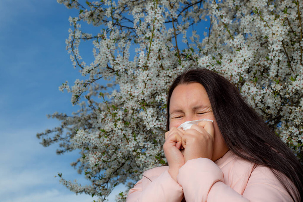 Mulher morena muito jovem com uma forte reação alérgica durante a primavera, espirros, stuffiness, conceito de saúde - Foto, Imagem