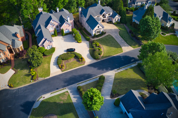 A beautiful Panoramic aerial view of cluster of beautiful houses, landscaped yards and fresh spring bloom on trees in an upscale subdivision in Suburbs of Georgia shot during golden hour. - Photo, Image