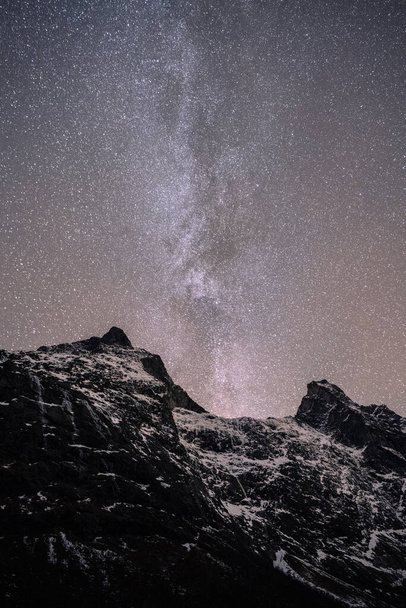 A vertical shot of a beautiful snowy landscape under the Milky Way sky background - Foto, Bild