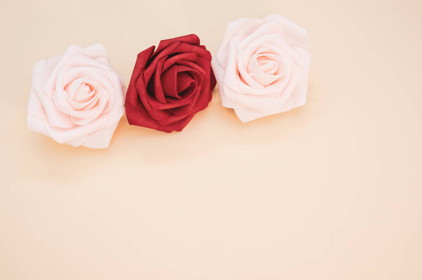 A closeup shot of red and pink roses on a light background with space for text - Fotografie, Obrázek