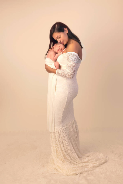Beautiful young mother in a white lace gown posing with her 7 days old newborn son - Φωτογραφία, εικόνα
