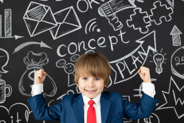 Bright idea! Funny child student in class against black chalkboard. Happy kid pretend to be businessman. Online education and e-learning concept. Back to school - Foto, afbeelding