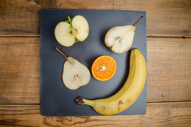 Manzana, pera, mandarina, plátano, plato plano, sobre tablas - Foto, imagen