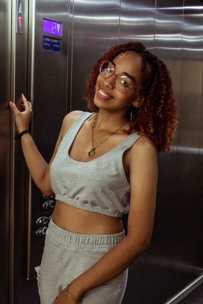Joven mujer afro con lentes on el ascensor - Fotoğraf, Görsel