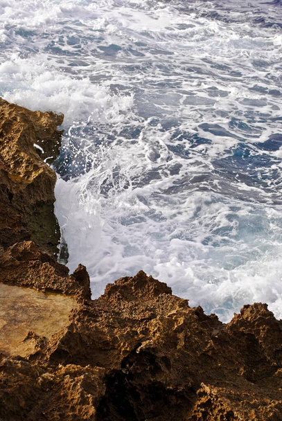 Az óceán becsapódása a sziklás partra habot hoz létre. Xlendi-öböl, Gozo, Málta és a Földközi-tenger egy viharos napon.  - Fotó, kép