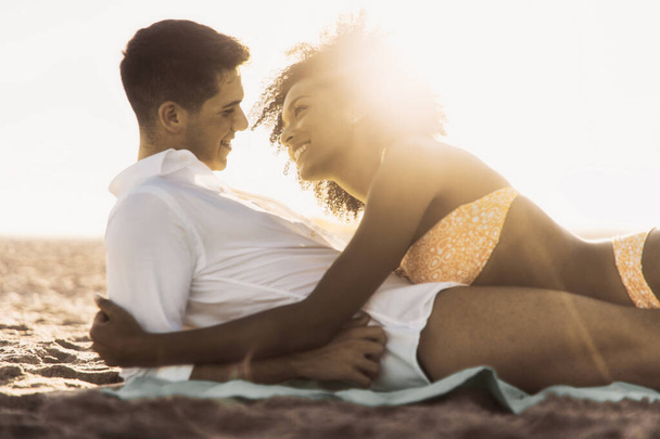 Interracial couple kissing on the beach in the summer - Valokuva, kuva