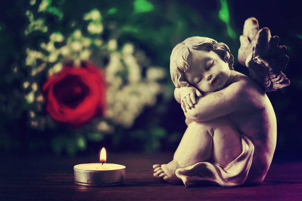 Карточка соболезнования со спящим ангелом и горящей свечой  - Фото, изображение