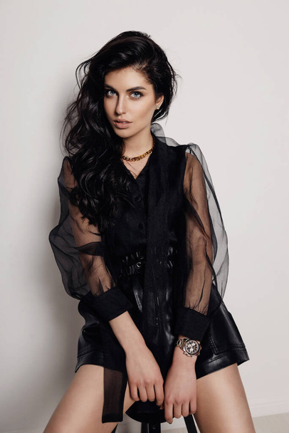 fashion photo of beautiful woman with dark hair in elegant dress and accessories posing in studio - Fotó, kép