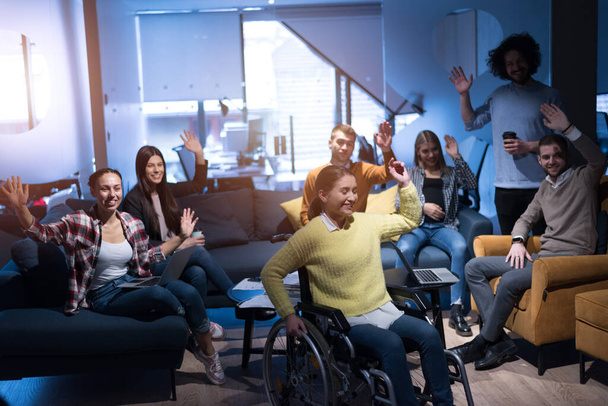 Happy Workers Have Fun in Modern Office, Handicaped Man on Wheelchair. Komunikace s kolegy. Koncept týmové práce a zdravotního postižení - Fotografie, Obrázek