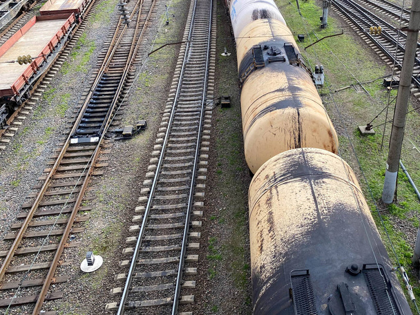 Widok z góry różnych wagonów kolejowych i zbiorników na kolei przemysłowej z szynami do transportu towarów i poprawy nowoczesnej logistyki. - Zdjęcie, obraz
