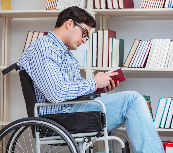 Disabled student studying in the library - Фото, изображение