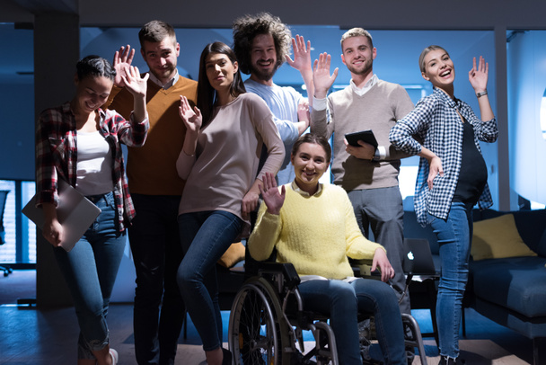 Happy Workers Have Fun in Modern Office, Handicaped Man on Wheelchair. Komunikace s kolegy. Koncept týmové práce a zdravotního postižení - Fotografie, Obrázek