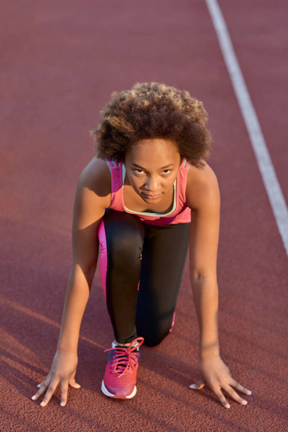 Sportos kislány áll rajtpozícióban a sprint előtt - Fotó, kép
