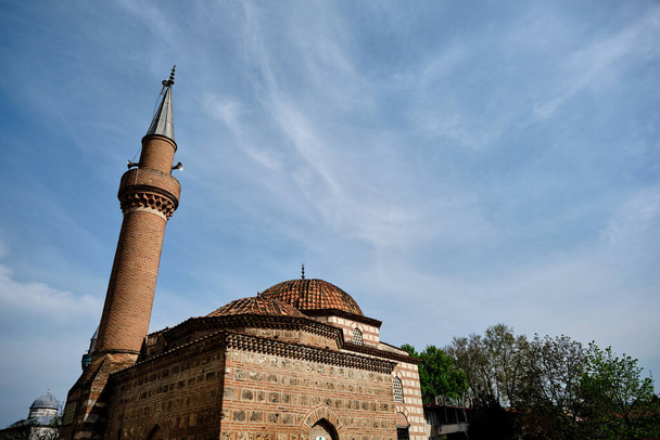 Niceia (iznik), Bursa Turquia. seyh kutbuddin e seu túmulo filho feito de parede de tijolos vermelhos com seu minarete se estende ao céu azul nublado com fundo mesquita verde (yesil cami). - Foto, Imagem