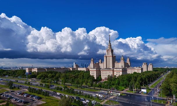 Moscou, Rússia - 17 de abril de 2021: Vista panorâmica aérea dos edifícios ensolarados do campus da famosa universidade de Moscou sob o céu nublado dramático na primavera - Foto, Imagem