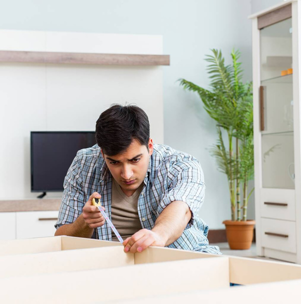 Man assembling furniture at home - Фото, изображение