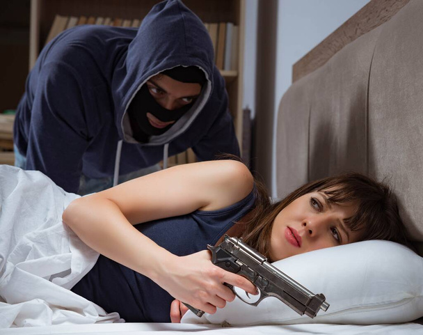 Грабитель вламывается в дом ночью в спальню со спящим wo - Фото, изображение