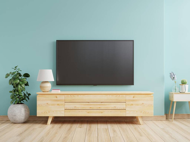 Mockup έναν τοίχο τηλεόραση τοποθετείται σε ένα σαλόνι με ένα μπλε τοίχο.3d απόδοση - Φωτογραφία, εικόνα